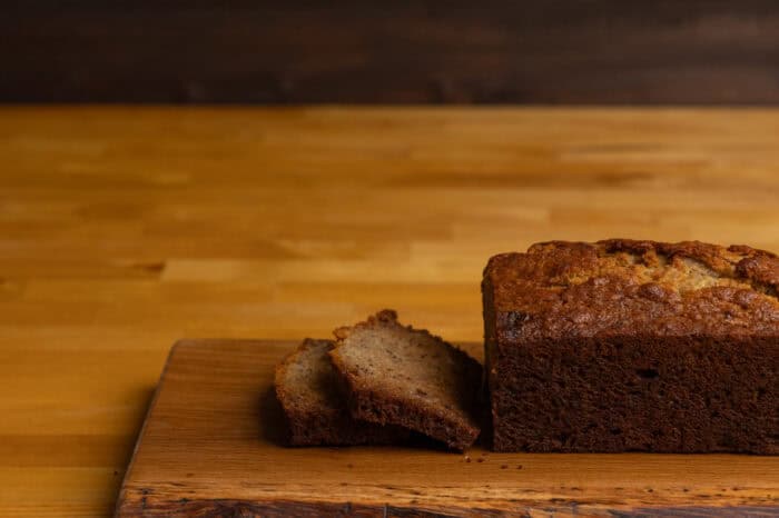 Banana bread sliced, sitting on a cutting board